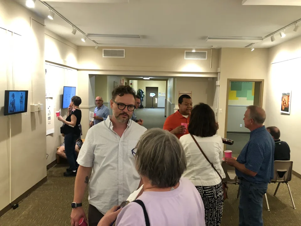 A view through the gallery with visitors gathering and talking during the show.