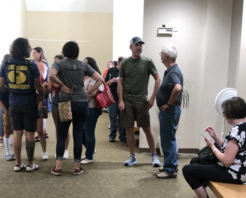 Visitors standing and sitting in the entrance area outside the gallery.
