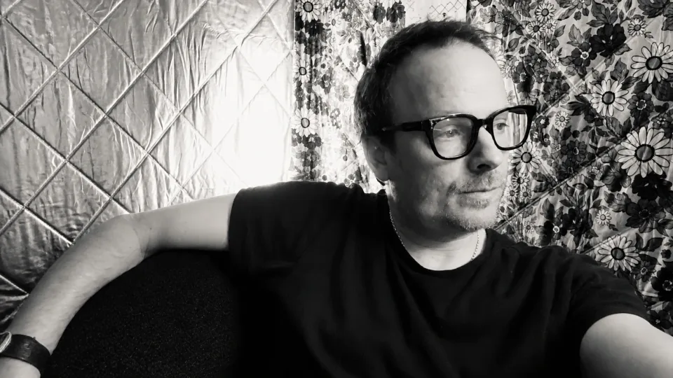 John N. Farmer in a black-and-white portrait, wearing glasses against a floral backdrop.